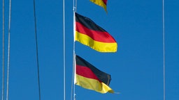 Mehrere Deutschlandfahnen an einem Fahnenmast.