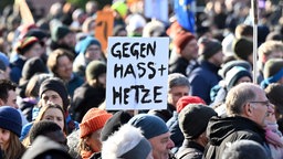 Bei einer Demonstration hält jemand ein Plakat mit der Aufschrift "Gegen Hass + Hetze" in die Höhe. Symbolbild