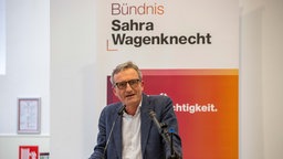 Thomas Geisel vor dem Banner "Bündnis Sahra Wagenknecht".