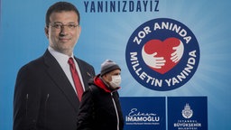 Archivbild: Eine Person geht an einem Plakat von Ekrem İmamoğlu vorbei.