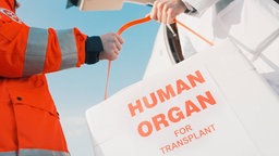 Übergabe eines Spendeorgans, Transportgefäß mit Aufschrift "HUMAN ORGAN FOR TRANSPLANT", Universitätsklinikum Essen