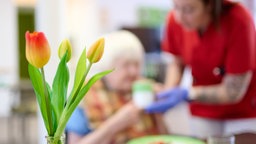 Eine Pflegekraft unterstützt eine Seniorin beim Essen. Symbolbild: Pflegeversicherung