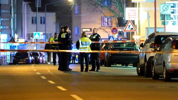 Schatten einer Waffe auf dem Schriftzug "POLIZEI" an der Tür eines Einsatzfahrzeugs. Symbolbild