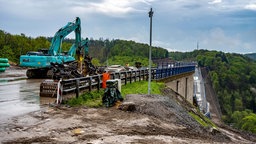 Nach der Sprengung der Rahmedetalbrücke in Lüdenscheid beginnen die Aufräumarbeiten auf der Großbaustelle. Das bis zu 70 Meter hohe und 17 000 Tonnen schwere Bauwerk war am Sonntag in ein gigantisches Fallbett gestürzt.