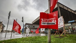 Plakate und Fahnen der IG Metall vor dem Werksgelände von Thyssenkrupp Steel in Duisburg.