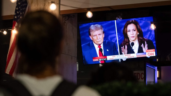 Donald Trump und Kamala Harris auf einem Fernseher beim TV-Duell der beiden US-Präsidentschaftskandidaten 