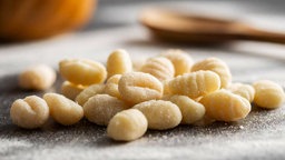 Frische Gnocchi liegen auf einer bemehlten Arbeitsfläche