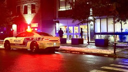 Symbolfoto: Ein Streifenwagen der Polizei in Montreal steht nachts auf einer Straße vor einem Gebäude. 