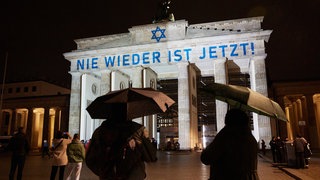 Der Schriftzug «Nie wieder ist jetzt» wird zum 85. Jahrestag der Pogromnacht an das Brandenburger Tor projiziert.