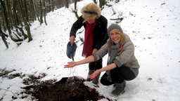 Antje Zimmermann lässt sich an einem verschneiten Hang Wasser über die Unterarme gießen