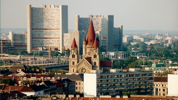 Blick auf das UNO-Zentralgebäude UNO-City und die Kirche Heiliger Franz von Assisi in Wien. 