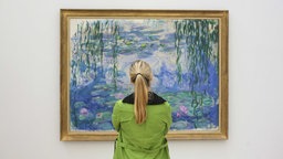 Symbolbild: Eine Frau steht am Dienstag (06.10.2009) im Von der Heydt-Museum in Wuppertal vor dem Bild "Seerosen" des Künstlers Claude Monet. 