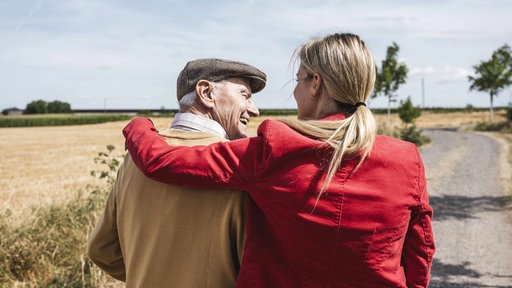 Zwei Personen, die Frau stützt den Mann, beide lachen