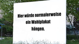 Ein weißes Wahlplakat auf dem steht: Hier würde normalerweise ein Wahlplakat hängen.