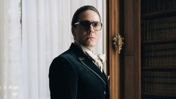 Daniel Brühl als Modeschöpfer Karl in einer Szene der Serie "Becoming Karl Lagerfeld".