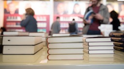 Archivaufnahme von 2023: Ausgestellte Bücher auf der Frankfurter Buchmesse, im Hintergrund Messebesucher.