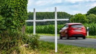 Zwei weiße Kreuze an einer Landstraße bei Kerken zum Gedenken an einen tödlichen Verkehrsunfall (2021).