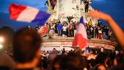 Anhänger des links-grünen Bündnises Neue Volksfront feiern in Paris am Place de la Republique