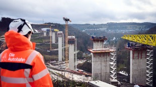 27.11.2024, Nordrhein-Westfalen, Lüdenscheid: Eine Sprecherin der Autobahn GmbH schaut auf die Baustelle der Rahmede-Talbrücke.