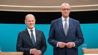 Bundeskanzler Olaf Scholz (SPD, l), steht neben Friedrich Merz, Unions Kanzlerkandidat und CDU Bundesvorsitzender, während dem TV-Duell von ARD und ZDF