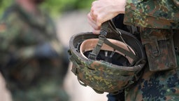 Helm in der Hand eines jungen Bundeswehr-Soldaten