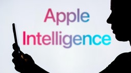 Silhouette einer Person, im Hintergrund ist das Apple Intelligence-Logo zu sehen.