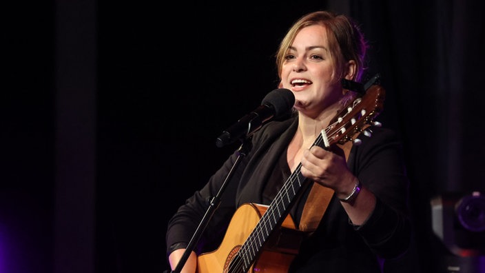 Fee Badenius mit Gitarre auf der Bühne vom Theater am Dom