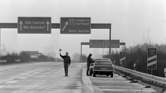 Polizisten kontrollieren Autofahrer am autofreien Sonntag in Köln, November 1973