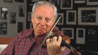 Der Violinist Isaac Stern auf seiner Geige spielend