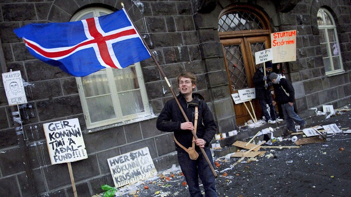 Mit der Landesfahne protestiert ein Isländer vor dem Parlament "Althing" in Reykjavik 