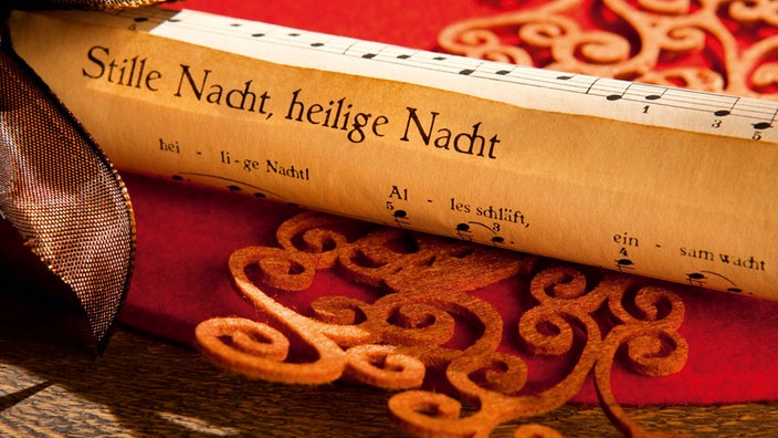 Aufgerolltes Papier mit dem Liedtext "Stille Nacht, heilige Nacht"