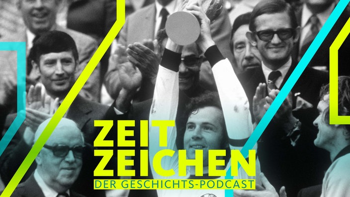 Der glückliche Kapitän Franz Beckenbauer (M) hebt an der Seite von Torhüter Sepp Maier (r) und dem englischen FIFA-Präsidenten Stanley Rous (l) den eroberten WM-Pokal triumphierend hoc