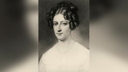 Eine Gemälde von 1870 zeigt eine junge Frau von schlanker Statur mir langem, schmalen Gesicht und dunklem, lockigem Haar