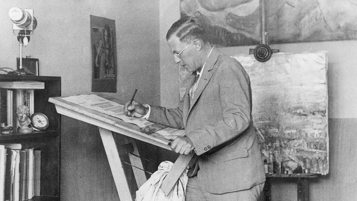 Der Bühnenbildner Caspar Neher steht in seinem Studio und malt. Aufnahme Anfang 1930er Jahre