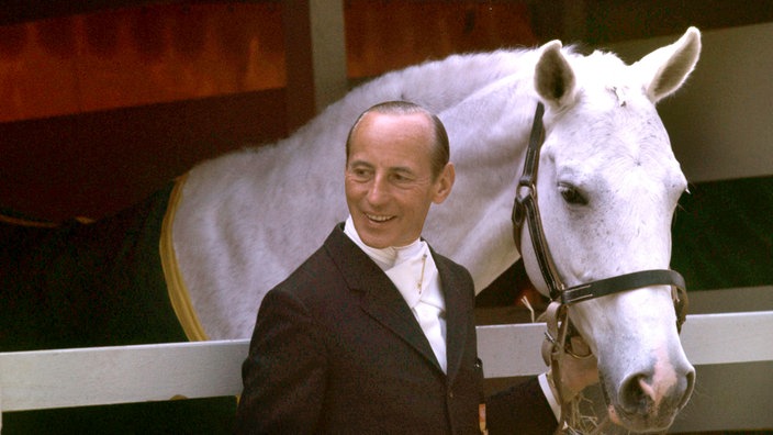 Der Unternehmer und Dressurreiter Josef Neckermann steht an der Box seines Schimmels Mariano, aufgenommen 1968 während während der Olympischen Sommerspiele in Mexiko