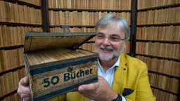  Leipzig: Hans-Jochen Marquardt, Vorsitzender des Literarischen Museums und Initiator der Reclam-Ausstellung, zeigt im Reclam-Museum in Leipzig eine Ausgabe der Reclam Wochenend-Bücherei, die zwischen 1927 und 1930 in einer Blechkassette auf den Markt kam