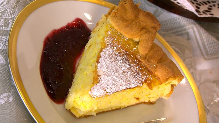 Ein Stück Welsche Riisflam mit Fruchtsauce auf einem Teller angerichtet