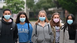 Schüler:innen des Gymnasiums Würselen stehen mit Maske nebeneinander auf dem Schulhof. 