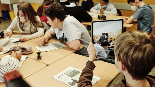 Schüler:innen mit Tablets in einem Klassenraum