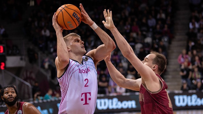 Sam Griesel (l.) von den Baskets Bonn vollführt einen Wurf