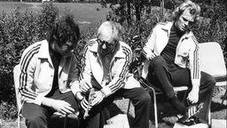 Franz Beckenbauer und Uli Hoeneß probieren im Mai 1974 gemeinsam mit Adi Dassler Fußballschuhe im Trainingslager in Malente an.