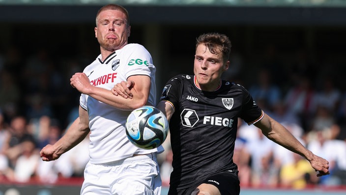 Verls Lars Lokotsch (l) im Kampf um den Ball mit Münsters Benjamin Böckle (r).