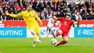 Ahmet Arslan (rechts) von Rot-Weiss Essen bei einer Grätsche gegen Torwart Marco Hiller vom TSV 1860 München.