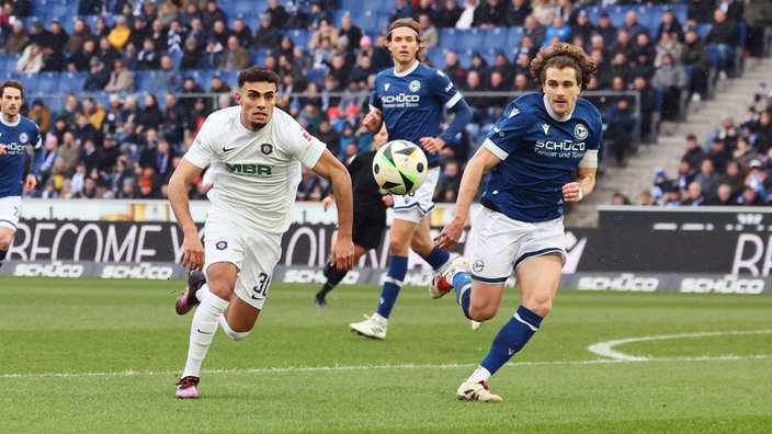 Aues Ali Loune (l.) und der Bielefelder Mael Corboz haben den Ball klar im Blick