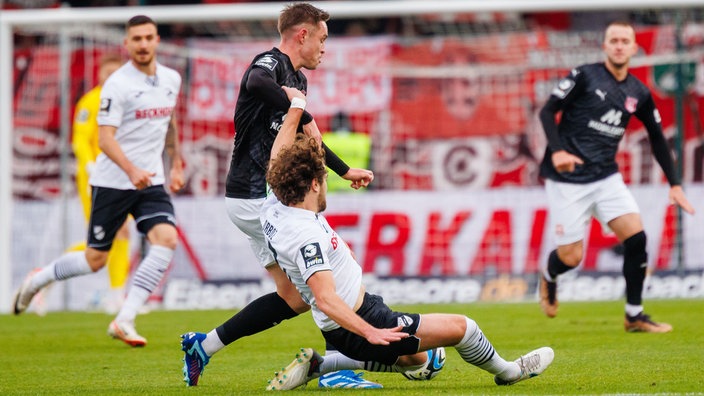 Aljaz Casar (Hallescher FC) wird von Verls Mael Corboz attackiert.