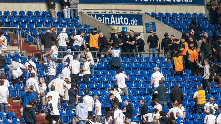 Schalker (weiße Shirts) und Frankfurter Fans prügeln sich nach dem Spiel auf der Tribüne.