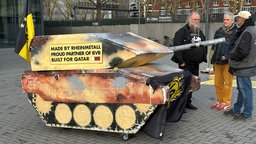 BVB-Fans und Mitglieder der DFG-VK protestieren mit einem Panzer aus Pappe vor den Westfalenhallen gegen den Werbedeal des BVB mit Rheinmetall