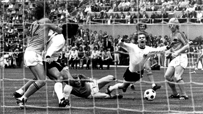  Fußball-WM-Finale am 07.07.1974 zwischen Deutschland und den Niederlanden: Bernd Hölzenbein (M) nach einem umstrittenen Foul durch den Holländer Wim Jansen (am Boden), links Gerd Müller, rechts der Holländer Wim Rijsbergen