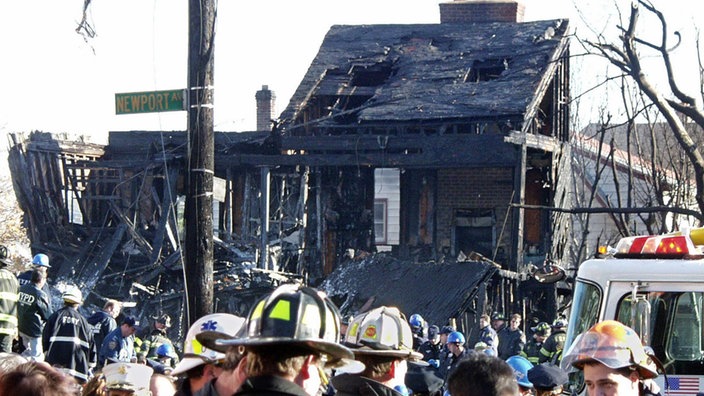 Rettungsmannschaften stehen an einem zerstörten Haus im New Yorker Stadtteil Queens