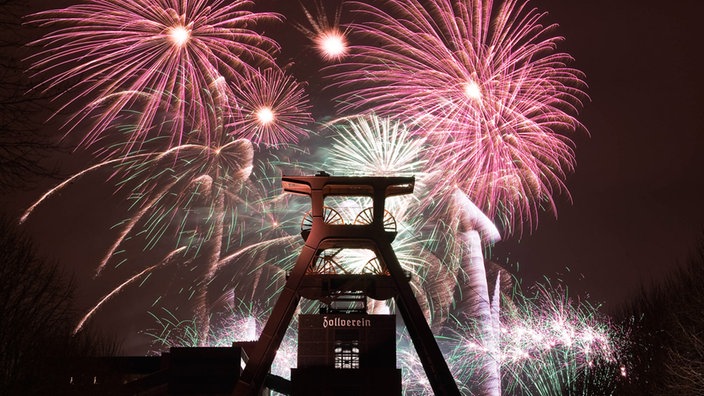 Feuerwerk im Vordergrund Förderturm der Zeche Zollverein